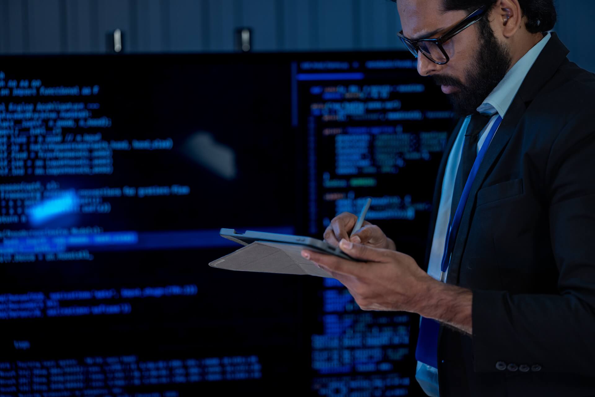 Professional reviewing NIST 800-171 compliance documentation on a computer.